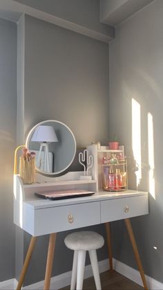 a white desk with a mirror and stool