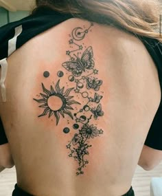 the back of a woman's shoulder with sun, moon and stars on it