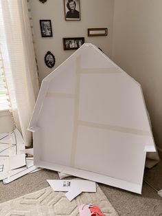 a doll house is sitting on the floor in front of some pictures and other items