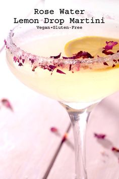 a lemon drop martini is garnished with rose petals