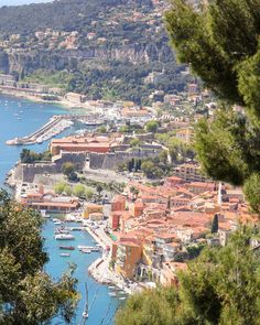 an aerial view of a city with boats in the water and trees surrounding it,