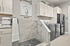 this kitchen has all white cabinets and marble counter tops, along with stainless steel appliances