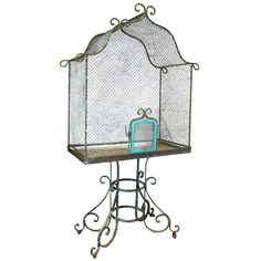 an iron birdcage with a teal purse on it's top stand