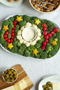 a platter filled with broccoli, cauliflower and olives next to other foods