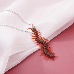 a very cute looking insect on a white cloth with beads around it's neck