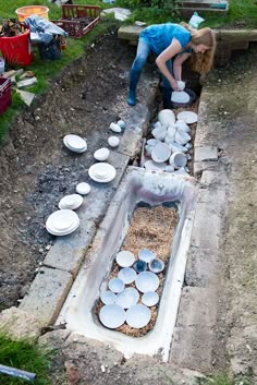 a woman is placing plates on the ground