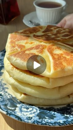 a stack of pancakes sitting on top of a blue and white plate