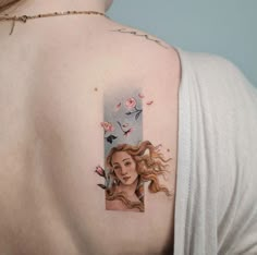 a woman's shoulder with a portrait tattoo on it