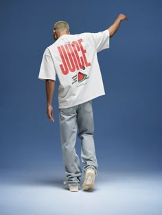 a man in white t - shirt and jeans standing with his hand out to the side