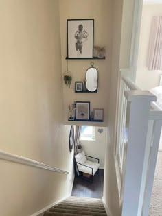 the stairs are lined with framed pictures and frames on them, along with other decor items