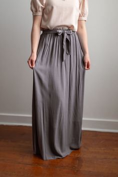 Breathing timeless charm, the Kristin pull-on style skirt features a comfortable elastic waistband with an attached tie belt at the waist front. It falls to the ankle in graceful gathers. Complete the feminine look with an elegant blouse. Fit: true to size Style: gathered dress skirt with elastic waistband and attached tie at the waist Color: charcoal Fabric content: 100% rayon Care instructions: wash gentle cycle, cold; lay flat to dry, cool iron if needed. For best results, always follow care instructions on garment label. Our sizing is always approximate and can vary due to personal preference and style. For the best experience - and to make life easier for everyone! - please carefully measure yourself before placing your order and allow 1" variance due to product manufacturing. If you Chic Flowy Maxi Skirt For Daywear, Elegant Maxi Skirt With Elastic Waistband For Day Out, Flowy Maxi Skirt With Elastic Waistband For Day Out, Flowy Lined Maxi Skirt For Daywear, Flowy Maxi Skirt With Elastic Waistband For Daywear, Flowy Tie Waist Skirt For Daywear, Chic Flowy Maxi Skirt With Gathered Waist, Gray Flowy Maxi Skirt, Flowy Maxi Skirt With Tie Waist