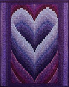 a purple and white quilt with a heart shaped design on it's center piece