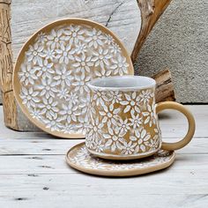 a coffee cup and saucer sitting next to each other on a wooden table top