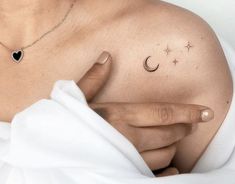 a woman's chest with a crescent and stars tattoo on it