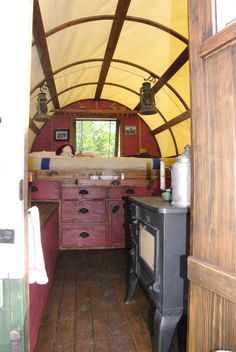 an old fashioned stove in the middle of a room with wood flooring and walls