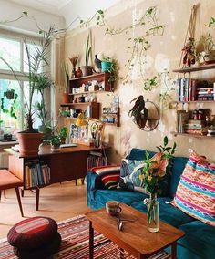 a living room filled with furniture and lots of plants on the wall next to a window