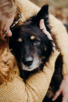 a woman petting a black and brown dog