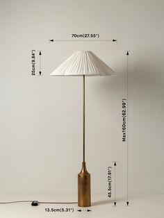 the floor lamp has a white shade on it's base and is next to measurements