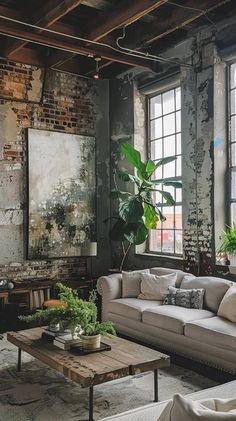 a living room filled with lots of furniture next to large windows on the side of a brick wall