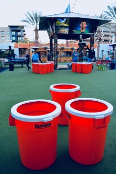 three red buckets sitting on top of a green field