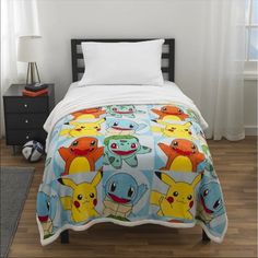 a bed with pokemon comforter and pillows on it