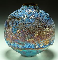 a blue and brown vase sitting on top of a table