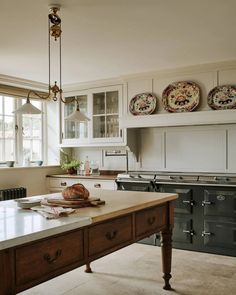 a kitchen with an island in the middle and two plates on the wall above it