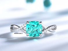 a ring with an aqua colored stone and white diamonds