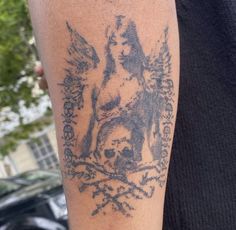 a man with a tattoo on his arm that has an image of a woman and skull