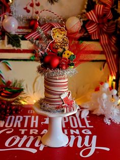 a cake decorated with christmas decorations and candy canes on a table in front of ornaments