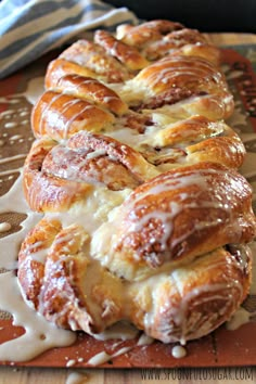 a close up of some breads on a tray with icing drizzled around them