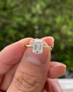 a person holding an engagement ring in their hand