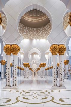 the interior of a large building with columns and arches on either side of the room