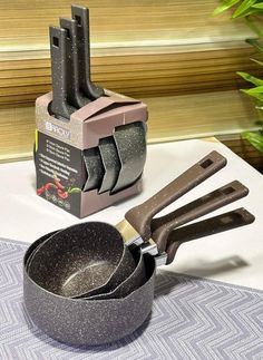 a pair of tongs sitting on top of a pan next to a knife sharpener