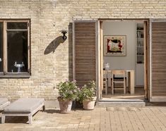 a brick building with shutters open to let in light