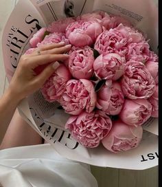 a woman holding a bouquet of pink flowers