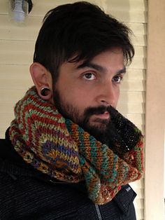 a man with a beard wearing a multicolored knitted scarf and earring