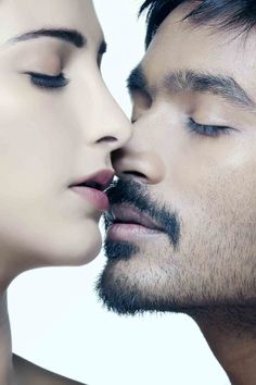 a man and woman kissing each other with their noses close to one another's face