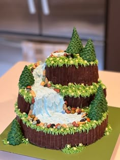 a cake that is shaped like a mountain with trees on top and water running down it