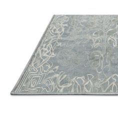 a gray rug with an intricate design on the top and bottom, in front of a white background