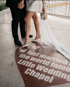 a bride and groom standing next to each other in front of a sign that says just married, the world famous little wedding chapel