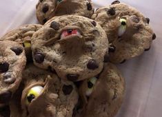 chocolate chip cookies with googly eyes are in a plastic container