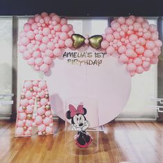 a minnie mouse birthday party with balloons and decorations