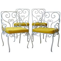 two white iron chairs with yellow cushions