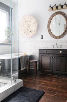 a bathroom with wooden floors and white walls