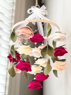 a wind chime with pink and white flowers hanging from it