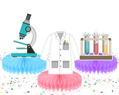 a lab coat, tutu skirt and microscope are on display in front of confetti