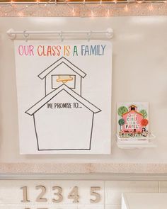 a bulletin board with the words our class is a family and a house on it