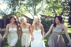 a group of women walking across a lush green field holding each other's hands