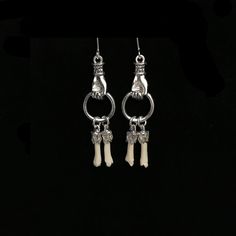 Tiny, real skunk toe bones hang from 1 inch silver plated, Victorian style hands. The small bones measure about .75 inch each.They hang from sterling silver French hook earrings.  These dainty bone earrings drop to almost 2 inches. The skunk toe bones are professionally cleaned and sterile. As with all of our natural animal products, these are harvested humanely from animals that are already deceased. None of our natural components are from animals that have been killed for the purpose of use in our jewelry, they are all by-products. This piece of jewelry is sent in a bubble pack envelope via US postal service, first class mail with insurance and comes in a gift box. International rate is $23. Buyers are responsible for any customs and import taxes that may apply. I am sorry, but Necromanc Unique Bone-colored Sterling Silver Jewelry, Unique Bone Colored Sterling Silver Jewelry, Handmade Sterling Silver Jewelry In Bone Color, Bones On Hand, Real Bone Jewelry, Animal Bone Jewelry, Small Bones, Taxidermy Jewelry, Hand Earrings